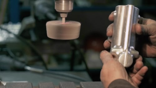 Handwerker sägt Metall mit Scheibenschleifer in Werkstatt, Moderne Eisenfabrik