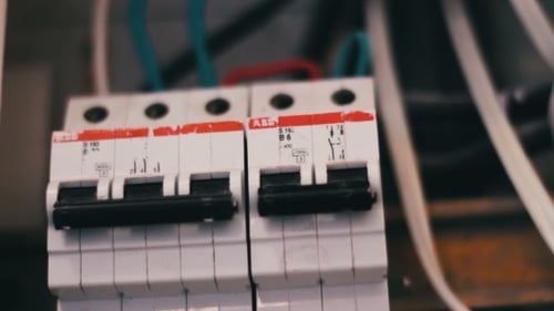 Hand Turns off Two Electrical Circuit Breakers