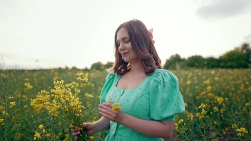 Portrait of Attractive Rural Woman with Bouquet in Rapeseed Field
