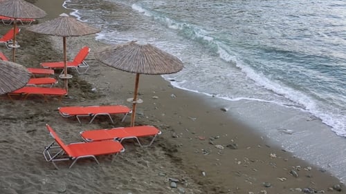 Empty Sunbeds Standing By a Blue Sea