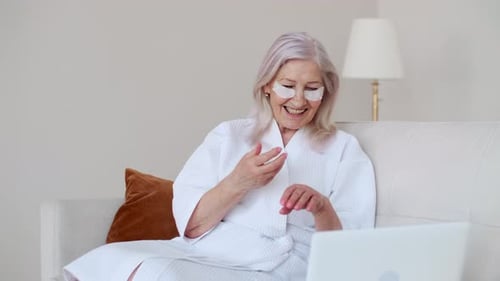 Woman Applies Lotion While Video Conferencing at Home