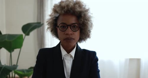 African young woman looking on camera inside modern office