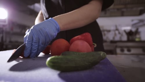 Person Slices Tomato in Kitchen