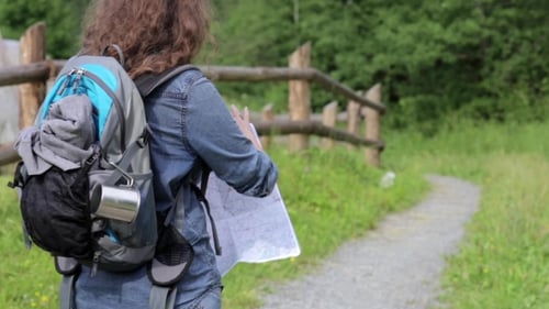 Hiker Reads Map on Path in Nature