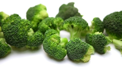 Fresh Green Broccoli Florets on White Surface