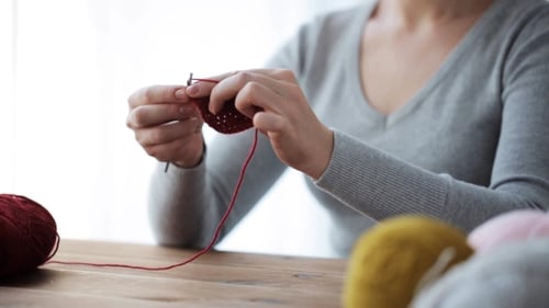 Close Up of Adult Knitting with Red Yarn