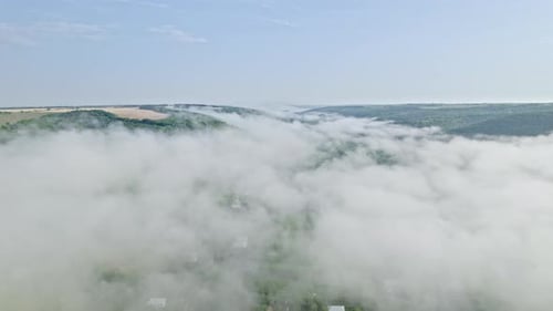 Aerial Drone View on Small Village in Valley Between Mountains During Misty Morning