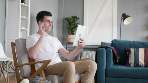 Man Video Calling on Tablet in Modern Living Room