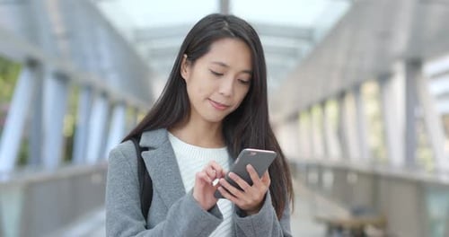Woman Using Smartphone for Voice Message in City