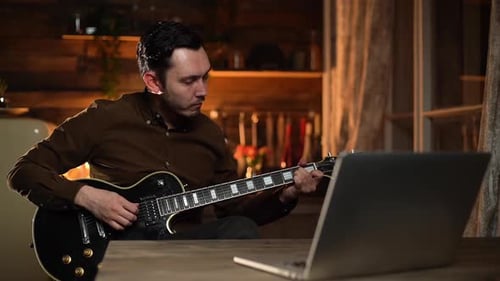 Young Adult Plays Electric Guitar at Home