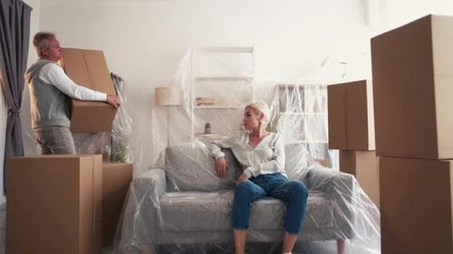Woman sits on sofa during move
