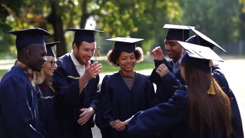 Graduates Celebrate with Hands Together Outdoors