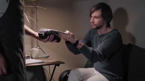Man Uses Tablet with Card Reader Indoors