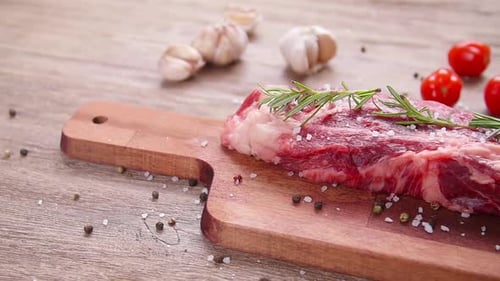 Raw Steak with Rosemary, Salt, Pepper, and Tomatoes
