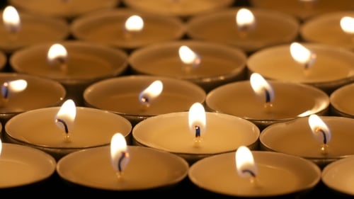 Multiple Tea Lights Candles Flickering Warmly in the Dark