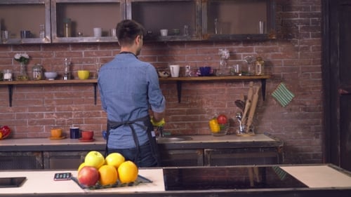 Man Washing Dishes Talks with Woman in Kitchen