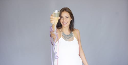 Woman Cheers Champagne Glass at Birthday Celebration