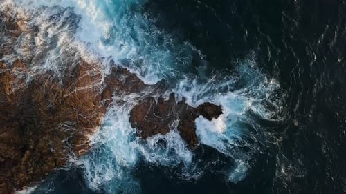 Overhead View of Waves Splash on Rocks
