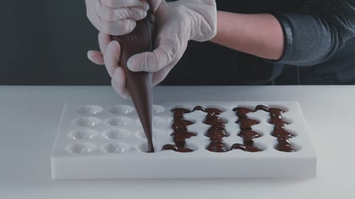 Dark Chocolate Being Piped Into Mold