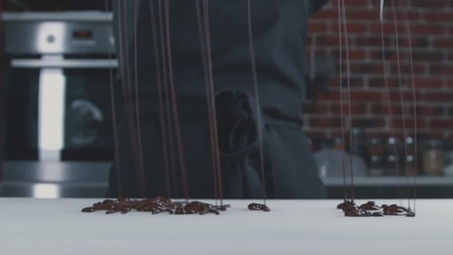 Herstellung von Pralinen, Süßigkeiten. Überschüssige Schokolade aus der Form entfernen.