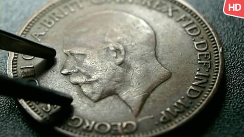 Close Up of Antique Coin held by Tweezers