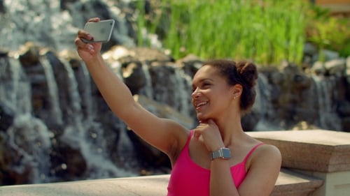 Woman Taking a Selfie by a Waterfall