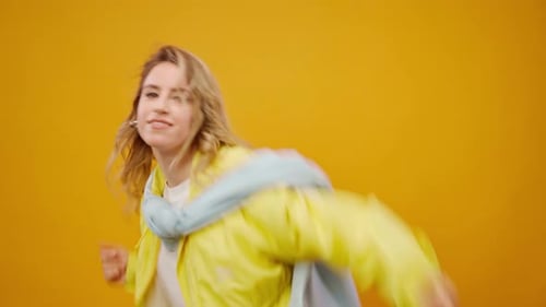 Woman Professional Dancer Dancing in Studio Against Yellow Background