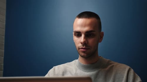 Young Adult Man Using Laptop Indoors