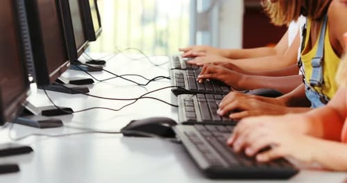 Schoolgirls using computer in classroom
