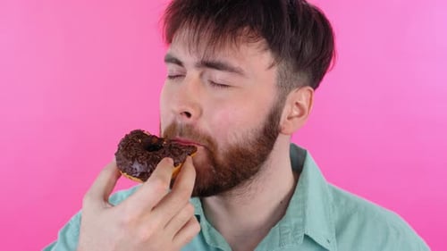Young Adult Enjoying Chocolate Donut Treat