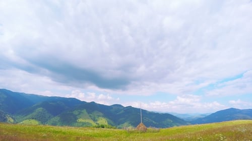 Summer Mountains Landscape with Haystack and Clouds.