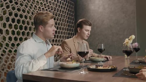 Friends Enjoying Food and Wine at Restaurant Table