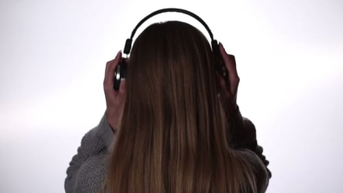 Back View Of Woman Listening Music In Headphones