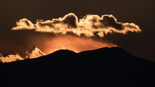 Von Sonnenuntergang und Wolken über Bergen