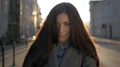 Jolie femme de race mixte marchant sur la rue d'automne sur le fond du coucher du soleil - belle fille marchant