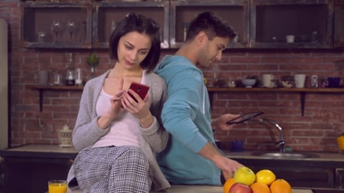 Couple Using Technology in Modern Kitchen