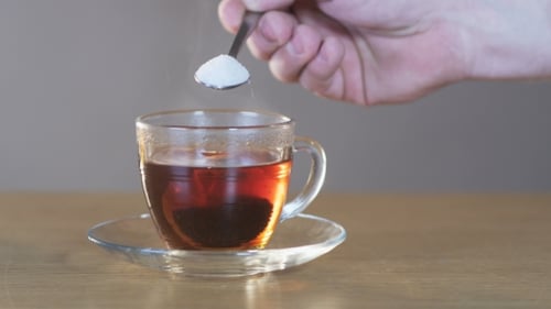 Man Puts Sugar Into a Cup