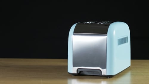 Golden Toast Pops Up from Light Blue Toaster