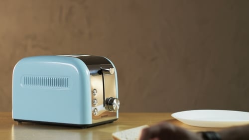 Person Toasts Bread in a Light Blue Toaster