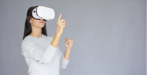 Woman Using VR Headset in Front of Gray Background