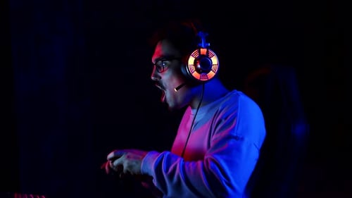 Excited Young Adult Gamer Celebrating Victory in Neon Lighting
