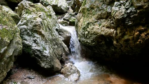Panning shot of mountain stream among stones