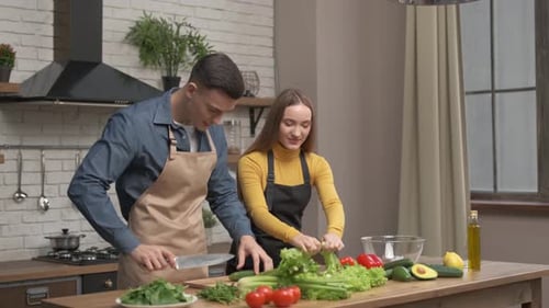 Couple Preparing Fresh Salad in Kitchen Together