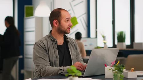 Business Man Using Laptop Typing Sitting at Table in Creative Cozy Office