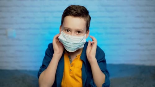Boy Puts on Surgical Mask and Gives Thumbs Up