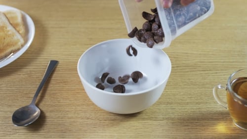 Cereal Being Poured into Bowl for Breakfast