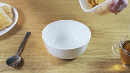 Pouring Cereal into a Bowl for Breakfast