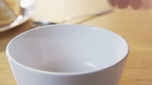Pouring Chocolate Cereal into a Bowl for Breakfast