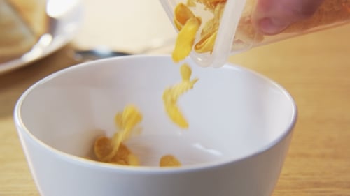 Corn Flakes Pouring into Bowl for Breakfast