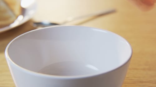 Cereal Pouring into White Bowl for Breakfast